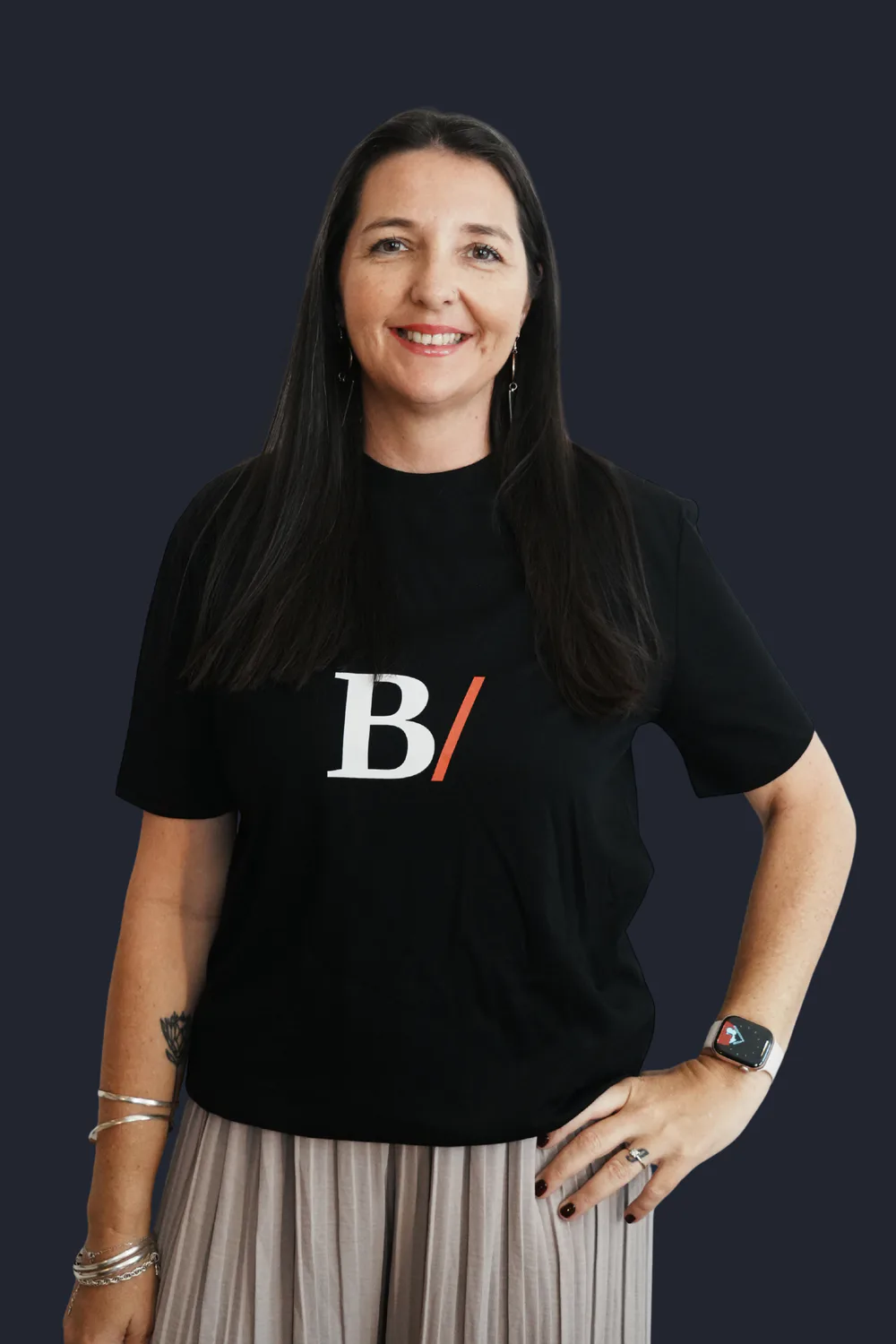 Heidi Hein smiling, one hand on hip, wearing a black Built With Skills T-shirt
