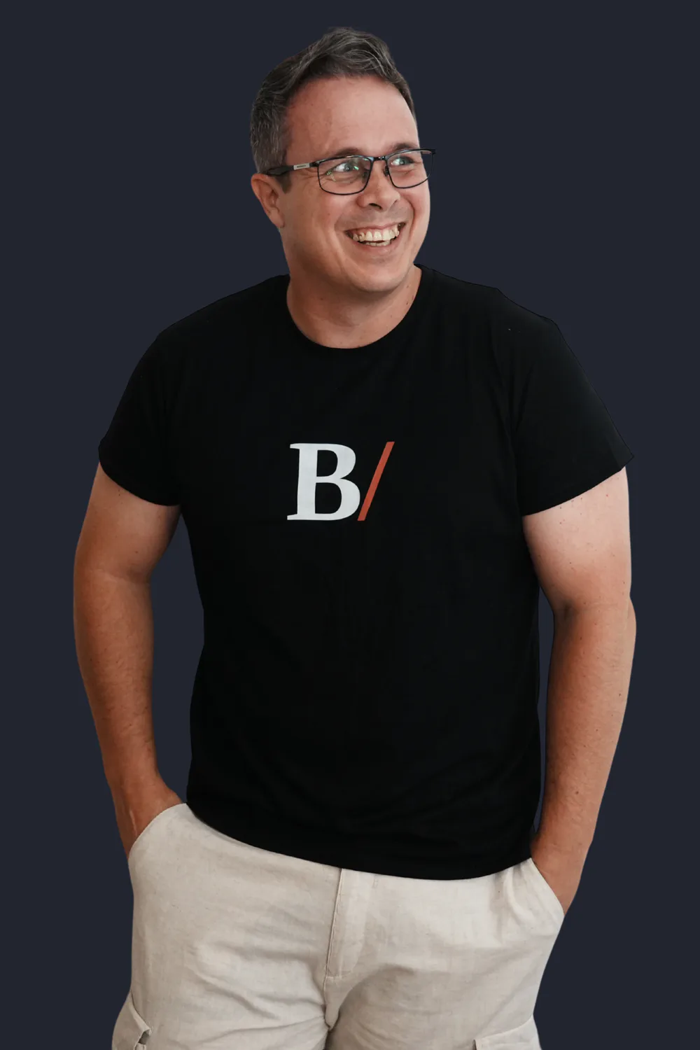 Jethro Pickering smiling, hands in pockets, wearing a black Built With Skills T-shirt